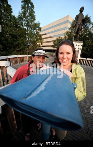 Two women at Resolution Park with the Captain James Cook statue in the background, Anchorage,  Alaska Stock Photo