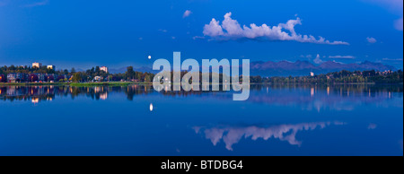 Twilight view of full moon over Westchester Lagoon in downtown Anchorage, Southcentral Alaska, Fall Stock Photo