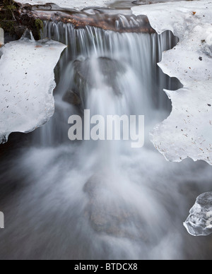 Cascade of water flows over melting ice at Falls Creek on the Turnagain Arm, Southcentral Alaska, Spring Stock Photo