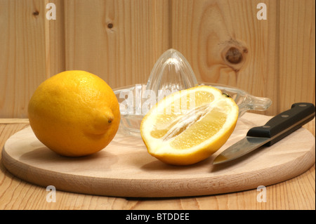 some organic lemon on a timber board and a knife Stock Photo