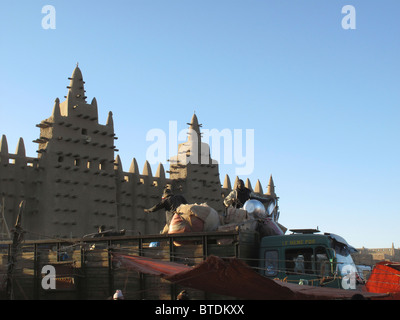 Djenne mosque built of sandstone and a truck travelling past it Stock Photo