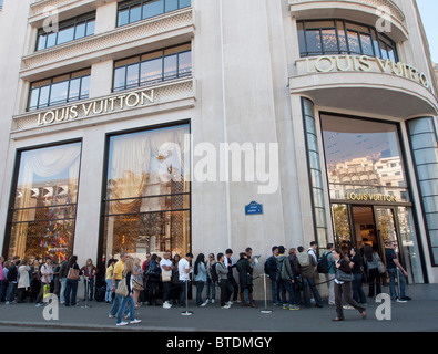 Queue of shoppers outside Louis Vuitton store on Champs Elysees in Paris France Stock Photo