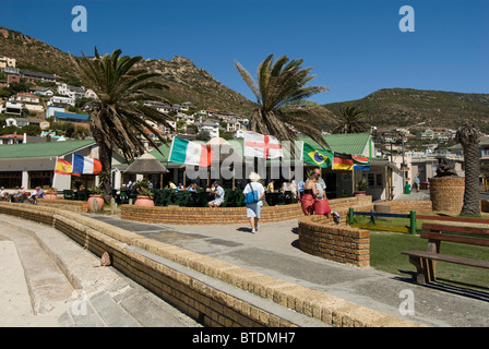 Galley Restaurant with patrons eating on the veranda and flags of different countries blowing in the wind Stock Photo