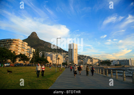 Walkers and joggers with Lions Head in back at Sea Point beachfront Stock Photo