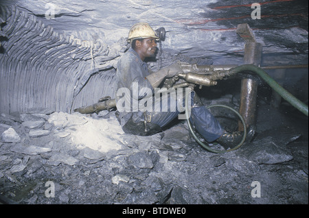 Drilling in an underground gold mine showing the cramped working conditions Stock Photo