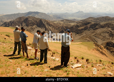 Tourists looking at Kunene River valley, Serra Cafema Mountains and Angola in background Stock Photo