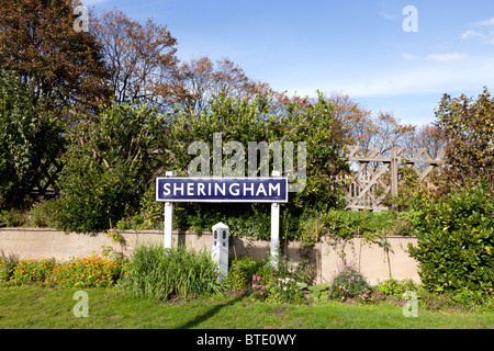 Traditional old style railway station sign and flower beorders at Sheringham, Norfolk, England Stock Photo