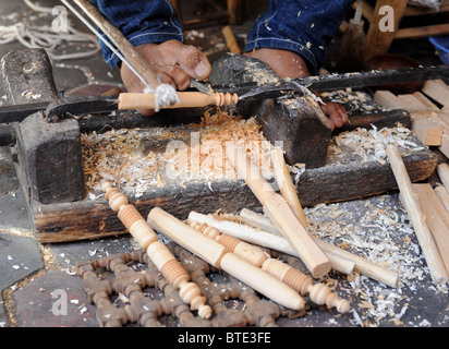 A craftsman carves articles from wood with a lathe using his feet in a souk in Marrakech. Stock Photo