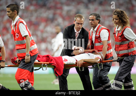 Paramedics carry a stretcher for an injured player onto the pitch ...