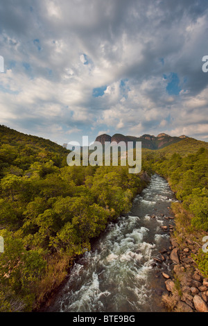 A fast-flowing stream with the three rondawels in the distance Stock Photo