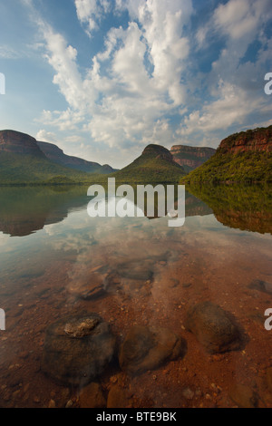 River reflecting the sky and the Blyde River Canyon and three rondawels in the distance Stock Photo