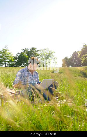 Young man using laptop computer in park Stock Photo