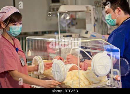 Doctor and nurse examining newborn baby in incubator Stock Photo