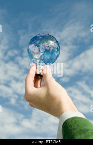 Person holding light bulb in front of sky Stock Photo