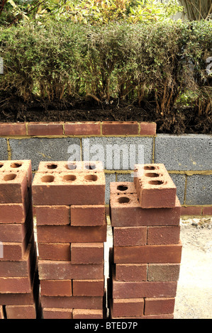 Red bricks used to build garden wall. Stock Photo