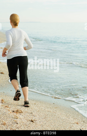 Woman jogging at the beach Stock Photo