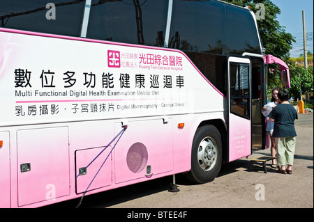 Doctor receiving patient at mobile women's health exam bus in parking lot, Taiwan Stock Photo