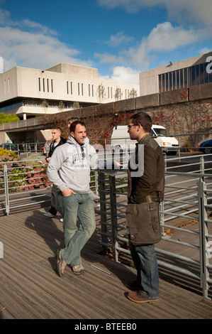 Two students talking on the campus of Aberystwyth University, Wales UK Stock Photo