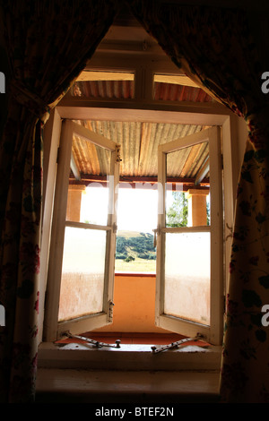 View from inside a rustic farmhouse through an open window Stock Photo