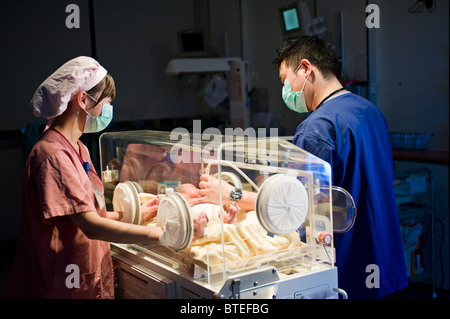 Doctor and nurse examining newborn baby in incubator Stock Photo