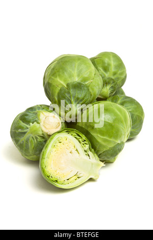 Whole and sliced Brussels Sprouts pile from low perspective isolated against white. Stock Photo