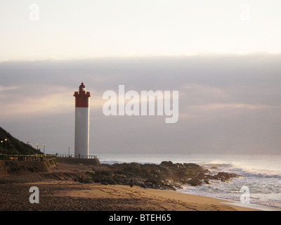 Lighthouse at Umhlanga rocks with waves breaking on the shore Stock Photo