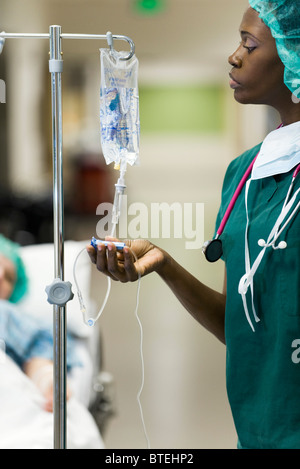 Nurse checking flow of saline from patient's IV drip