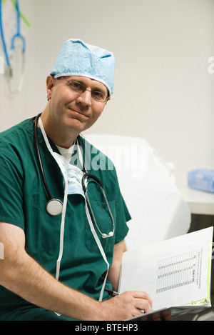 Surgeon reviewing patient's medical chart, portrait Stock Photo