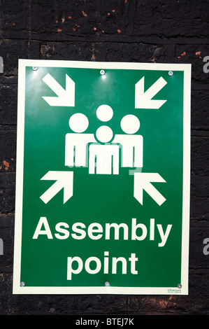 Assembly point sign on wall in Manchester UK Stock Photo