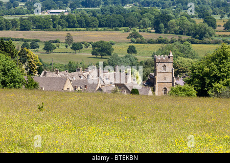The Cotswold village of Bourton on the Hill, Gloucestershire tucked in beneath the slope. Stock Photo