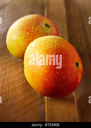 Fresh whole mini mango on a wooden table Stock Photo