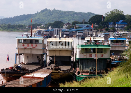 Chinese cargo boats from China used to import and export goods are docked on the Mekong River in Chiang Sean, Thailand. Stock Photo