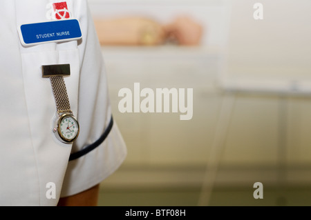 Close up of a nurse fob watch and university student nurse badge on a white uniform Stock Photo