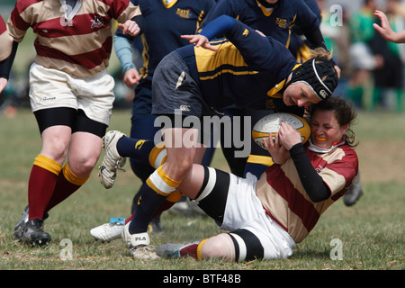 Navy ball carrier is tackled by a Norwich University player during a women's match at the annual Cherry Blossom Rugby Tournament Stock Photo