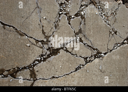 Broken concrete sidewalk caused by heavy equipment driving over it Stock Photo