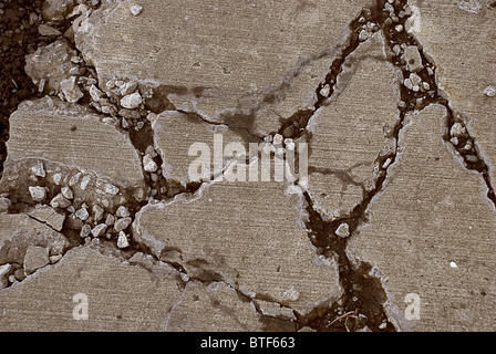 Broken concrete sidewalk caused by heavy equipment driving over it Stock Photo