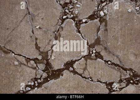 Broken concrete sidewalk caused by heavy equipment driving over it Stock Photo