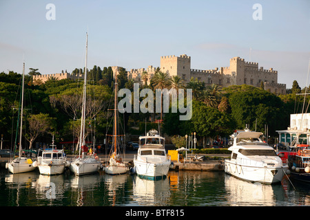 Mandraki Harbour with view over the Palace of the Grand Masters, Rhodes old Town, Rhodes, Greece. Stock Photo