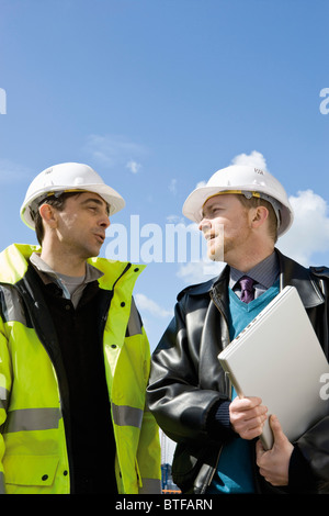 Building contractor and businessman in hard hats Stock Photo