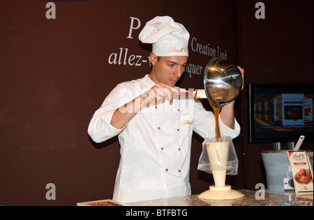 A chef pours chocolate into trays to make Lindt chocolates, ' Salon du Chocolat', Paris, France