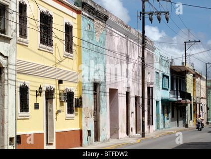 A motorcycle passes a row of colourful houses in Merida in the Yucatan in Mexico Stock Photo