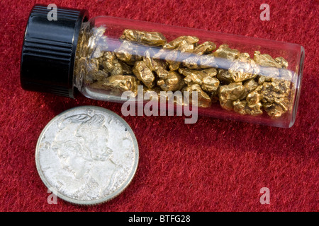 Natural Gold Nuggets in Vial beside Mercury Dime Stock Photo