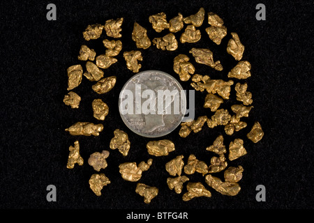 Natural Gold Nuggets beside Silver Mercury Dime Stock Photo