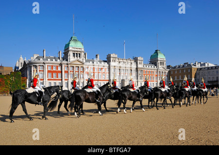Household Cavalry arriving on Horse Guards Parade for Changing the Guard ceremony Admiralty Extension building beyond Westminster London England UK Stock Photo