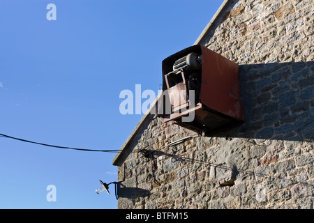 Abstract electrical machinery on wall of farm building. Stock Photo