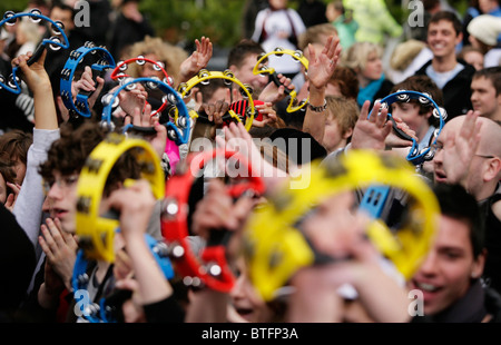 A crowd of young people holding tambourines in the air during a live music performance in Birmingham, UK Stock Photo