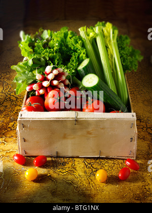 Box of fresh salad vegetables in a kitchen setting Stock Photo