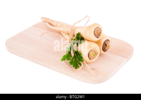 Parsley roots on a cutting board isolated on white background. Stock Photo