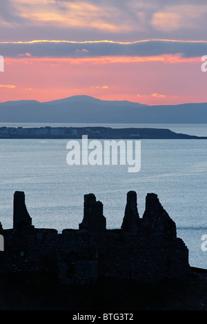 Dunluce Castle, County Antrim, Ulster, Northern Ireland, UK. Silhouette of ruins at sunset. Stock Photo