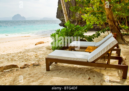 Two beach beds under the palms on Asian beach Stock Photo